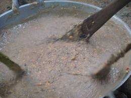 Bubur Asyura sedang dikacau dengan pengayuh kayu di dalam kawah besar