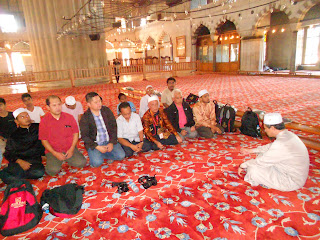 Ahli rombongan duduk berehat di atas permaidani merah di dalam Masjid Biru