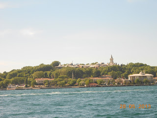 Pemandangan Istana Topkapi di atas bukit berhutan dilihat dari Selat Bosphorus