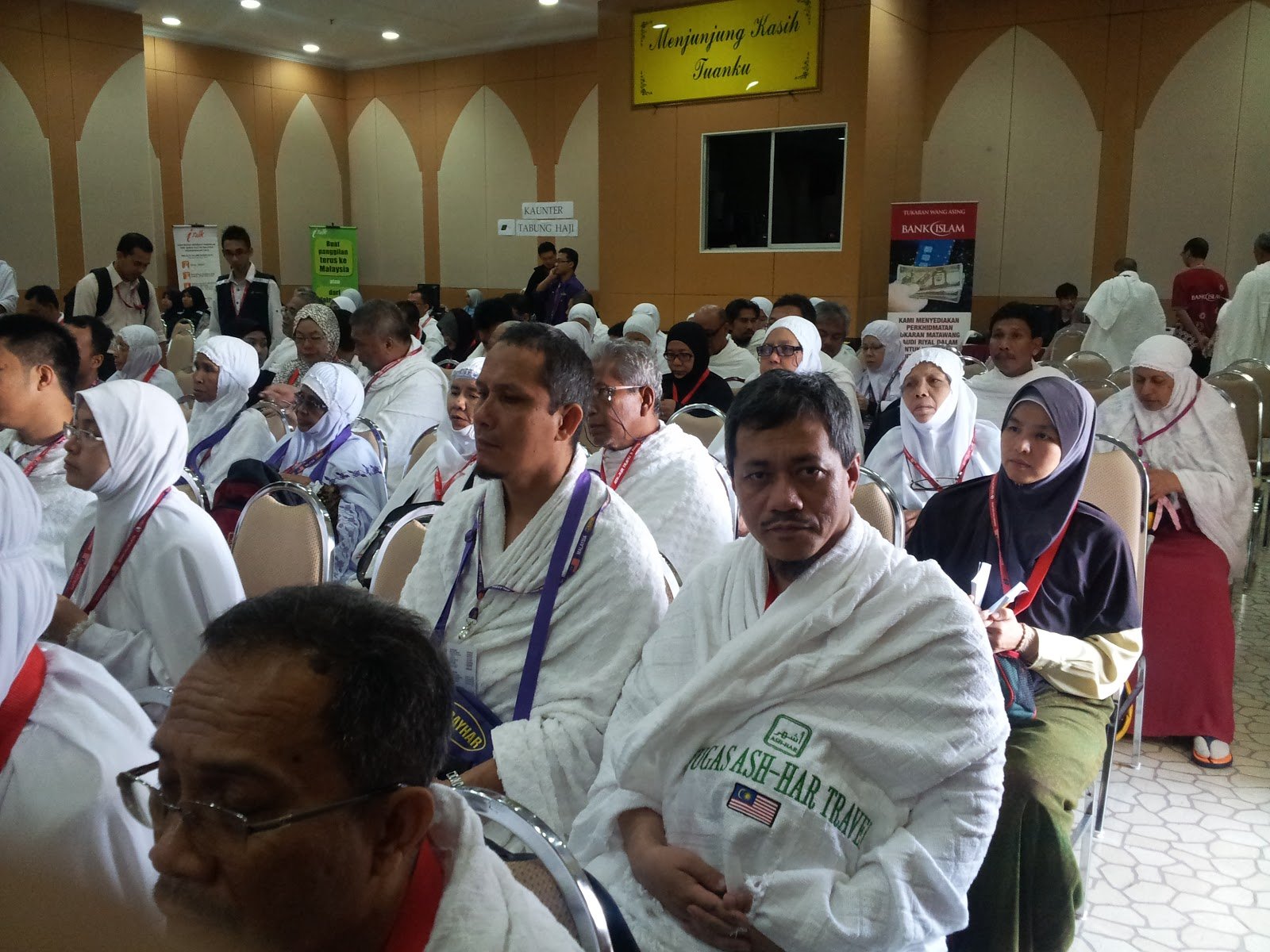 Jemaah haji berpakaian ihram berkumpul mendengar taklimat di dewan pelepasan Kompleks Haji Kelana Jaya