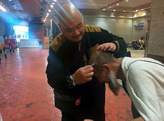 Seorang pembimbing mencukur kepala jemaah haji dari China untuk bertahallul di ruang bawah tanah Menara Jam Makkah